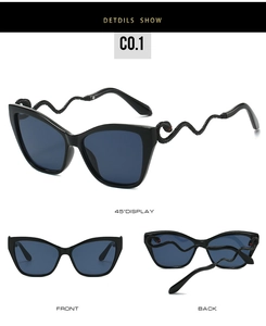 Detail of snake-shaped temples with scale textures and red eye accents on cat-eye sunglasses