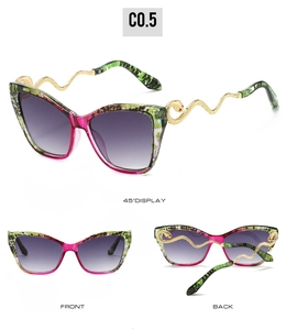 Macro detail of cat-eye sunglasses with purple gradient lenses and golden snake temples