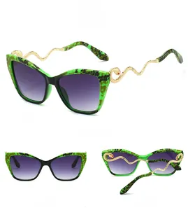 Macro detail of cat-eye sunglasses with leopard frame and gold snake-shaped temples