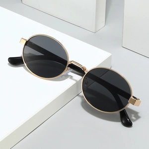 Vintage oval metal sunglasses with gold frame and dark lenses on minimalist pedestal
