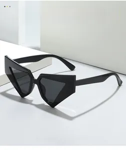 Macro detail of glossy black triangle sunglasses showing hinge on geometric white stairs