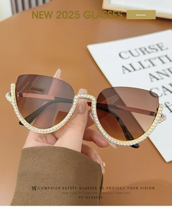 Detail of semi-rimless cat eye sunglasses with gold frames and pearl embellishments