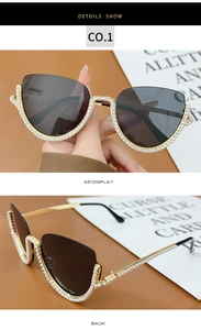 Detailed view of cat eye sunglasses with gold frame and decorative white pearls