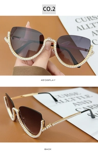 Detail view of cat eye sunglasses with white pearls and gold metal trim on gradient lenses