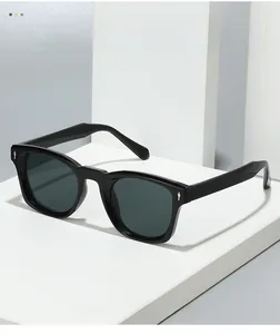Detail of square black sunglasses featuring diamond-shaped metal rivets on the side frame