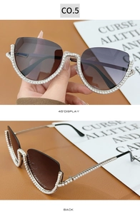 Detail of half-frame cat eye sunglasses featuring white pearl-encrusted edges and dark lenses