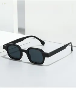 Detail of trendy black hexagonal sunglasses frame on a minimalist textured background