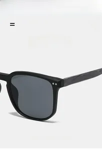 Detail shot of black square sunglasses featuring textured wood grain temples and matte finish