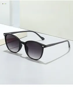 Detail of dark wood grain temples and silver rivet hinges on oval retro sunglasses