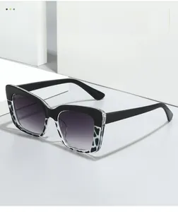 Vue détaillée de lunettes de soleil carrées bicolores avec verres dégradés sur socle blanc