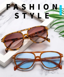 Macro shot of fashion sunglasses featuring tortoiseshell and amber frames with metal hinge detail