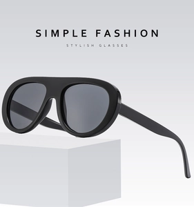 Detail of vintage oval black oversized sunglasses on a minimalist white display
