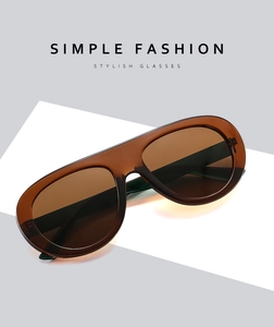 Macro shot of oversized amber sunglasses with translucent brown frames and dark UV lenses