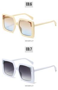 Dettaglio di occhiali da sole squadrati oversize color crema e bianco con lenti sfumate