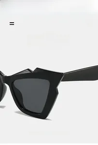 Detail of irregular geometric sunglasses frame in glossy black with elastic texture