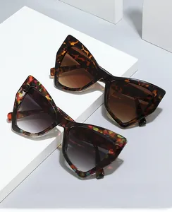 Close-up of cat-eye sunglasses in tortoiseshell and mosaic patterns on white pedestals