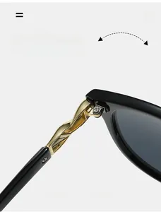 Detailed macro view of durable golden twisted metal hinges on vintage black sunglasses
