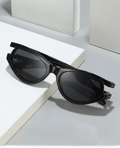 Close-up of trendy black oval frame sunglasses with gray lenses on a geometric stand