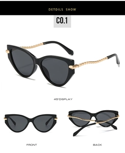 Detail of cat eye sunglasses featuring gold wave-shaped metal temples and black frames