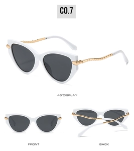 Cat eye sunglasses detail with white frame, black lenses and golden metal wave arms