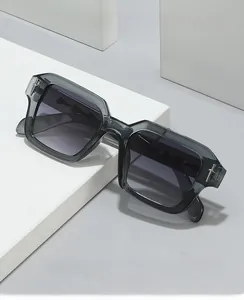 Detail of grey square sunglasses with silver dagger metal hinge on white geometric block