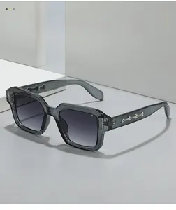 Detail of square sunglasses with translucent grey frames and silver metal temple decor