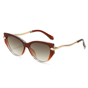 Fashionable cat eye sunglasses with amber frames, brown gradient lenses and gold chain temples