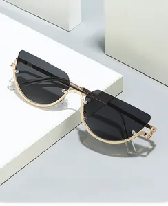 Detailed view of cat-eye half-frame sunglasses with gold metal trim and grey lenses