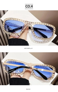 Détail de lunettes de soleil carrées dorées serties de strass avec verres bleus
