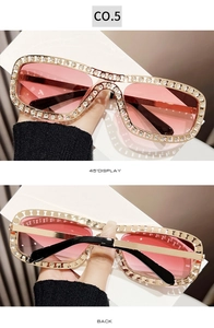 Détail de lunettes de soleil dorées avec strass brillants et verres dégradés roses