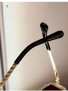 Détail de lunettes de soleil ovales avec des branches ergonomiques en métal courbé
