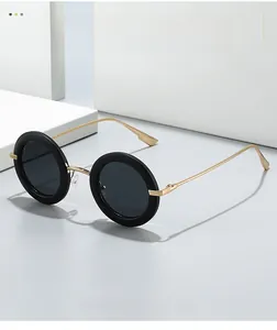 Macro detail of retro oval sunglasses featuring black frames with elegant gold temples