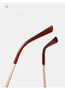 Detail of ergonomic curved amber resin and light gold metal temples for eyewear