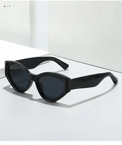Detail of chunky black cat-eye sunglasses with thick geometric frames and dark lenses