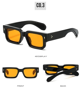Detail view of square sunglasses with thick black frame and transparent orange lenses