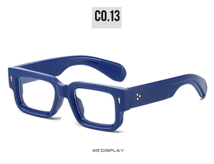 Detail view of navy blue square sunglasses with gold accents and chunky frame at 45-degree angle