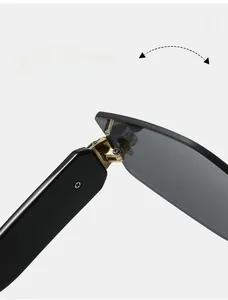 Close-up of durable golden metal hinges on rimless sunglasses with black temples
