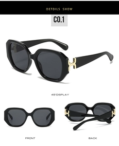 Detail view of square black sunglasses with gold H-shaped metal hinges and dark lenses