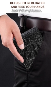 Sottile portafoglio da uomo con trama a coccodrillo infilato in una tasca dei pantaloni