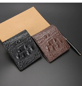 Primo piano di portafogli da uomo in texture coccodrillo nera e marrone con articoli da ufficio