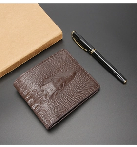 Detailed close-up of brown crocodile pattern embossed leather wallet with vintage texture