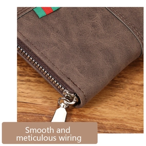 Close-up of brown leather men's wallet with green and red webbing and metal zipper