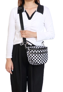 Detail of checkered crossbody bag with adjustable nylon strap and dual zipper closure