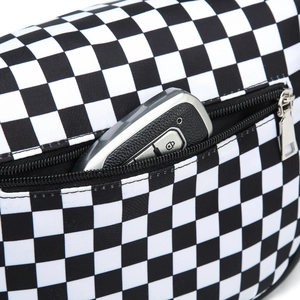 Detail of checkered nylon crossbody bag showing a zipper pocket containing a car key fob