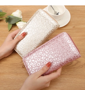 Detail of long leopard-embossed zip wallets in champagne gold and pale pink finish