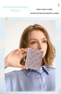 Close-up of lavender quilted mini wallet with embossed hearts and wrist strap detail