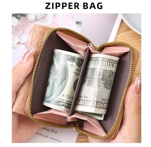 Pink quilted heart mini coin purse with two compartments shown holding rolled banknotes