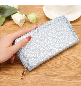Close-up of silver-blue glitter long wallet with leopard print and gold zipper detail