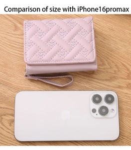 Mini pink wallet size comparison with iPhone 16 Pro Max on wood surface