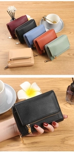 Detail view of colorful pebbled leather mini wallets with golden zippers on wooden desk